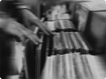 Manos recorriendo una batea de discos de vinilo